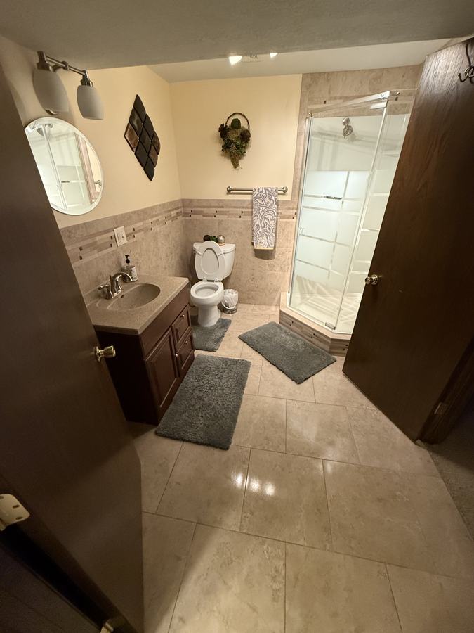 A clean bathroom, mats straightened and surfaces clear.